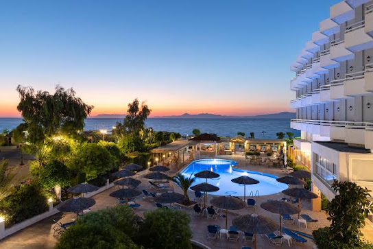 Seaside resort at dusk with pool and sea view